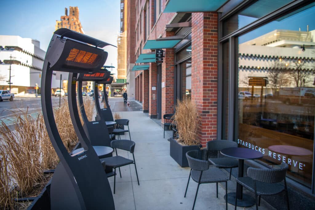 Multiple Bromic heaters lining outdoor coffee shop seating