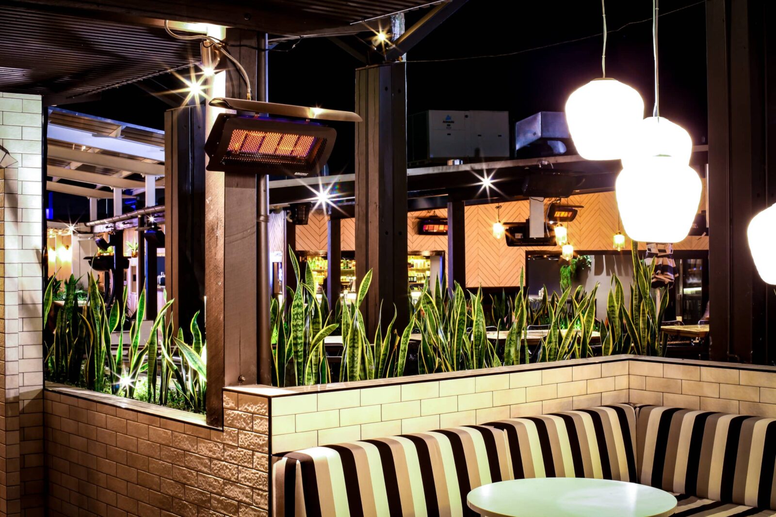 Single Booth Seating in Restaurant with decorative plant life and lighting